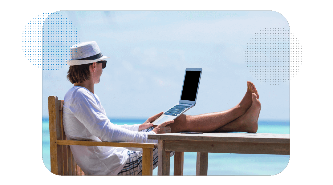 Pessoa trabalhando com um notebook no colo, com os pés pra cima em uma mesa e com roupa de praia.
